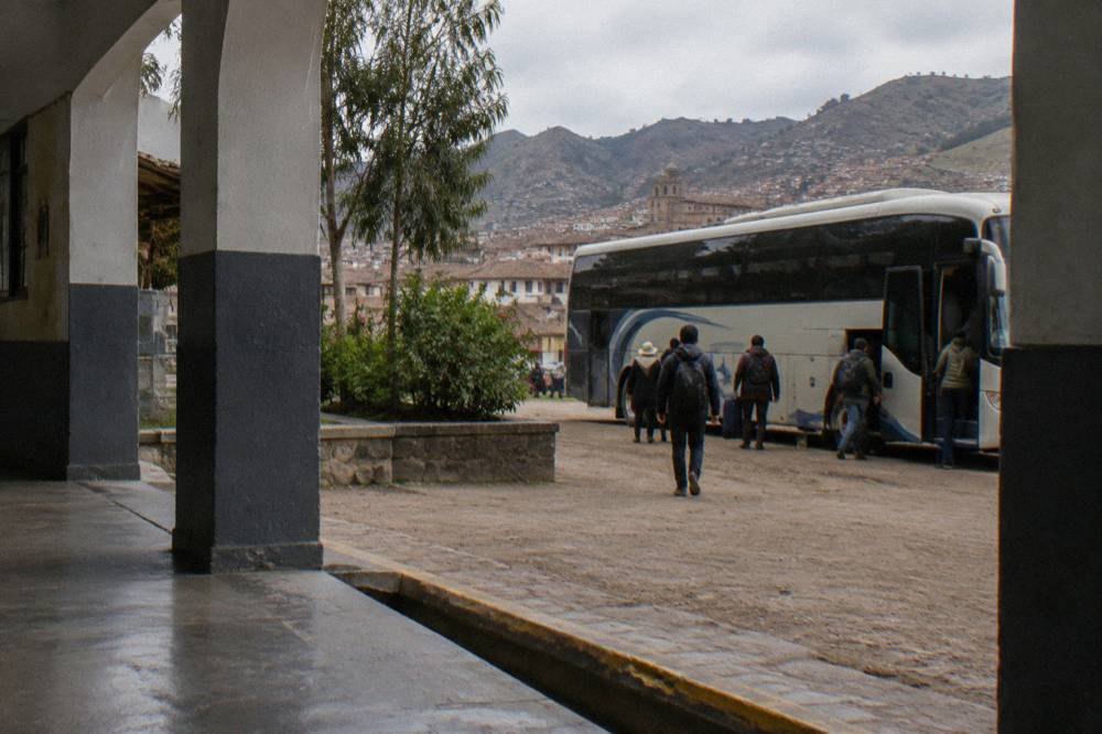 A bus terminal hall with departure counters and a coach loading at a platform