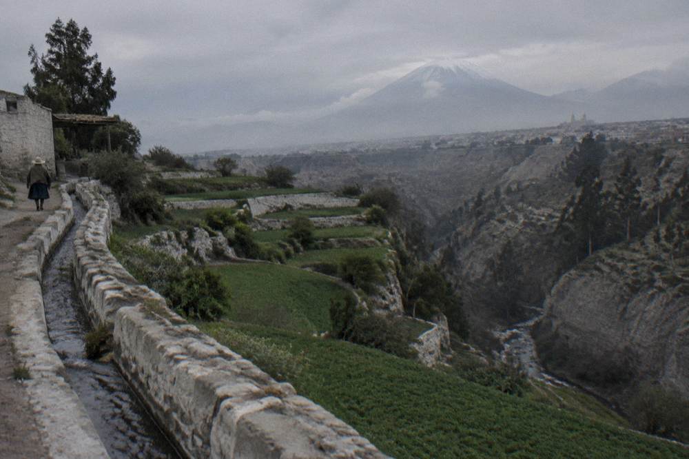 Deep canyon walls and terraced green fields near Chivay under a wide sky