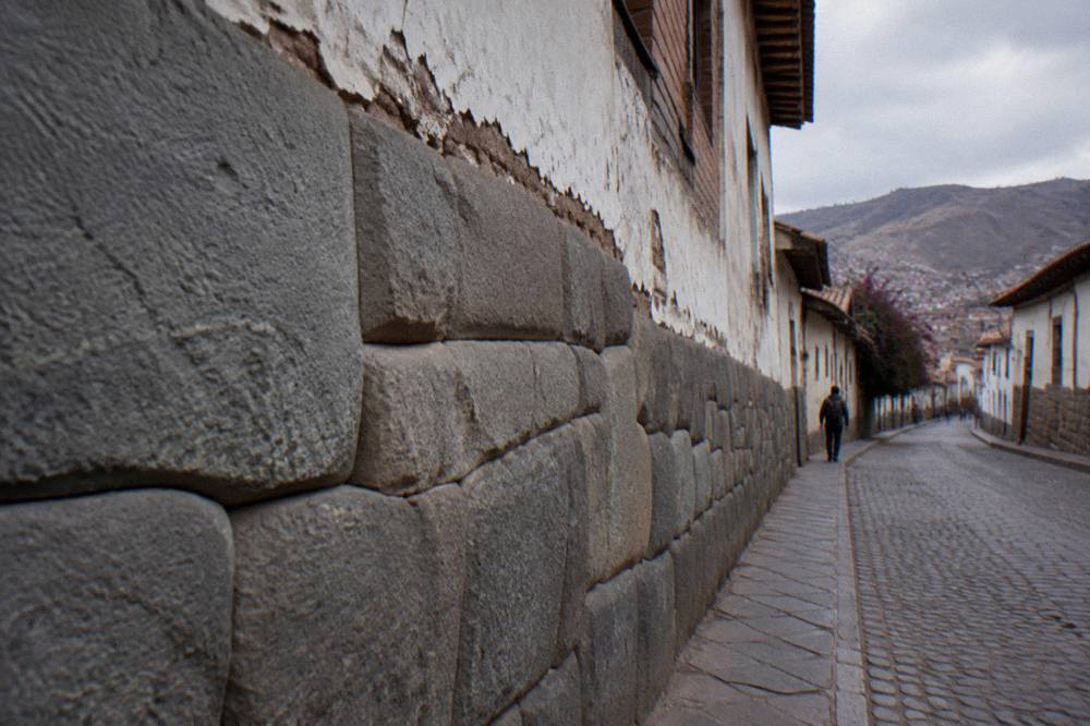 Ancient Inca stone wall forming the foundation of a colonial building in Cusco