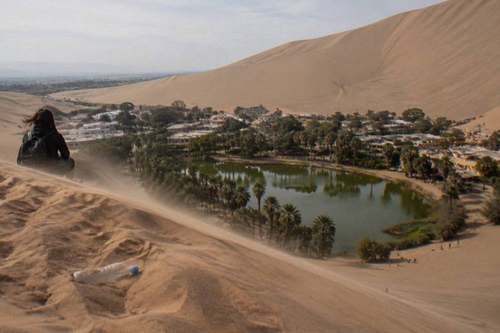 The Huacachina oasis lagoon ringed by sand dunes under a clear sky