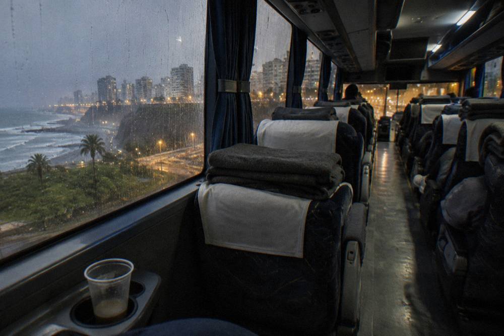 Rows of reclining bus seats with blankets folded on each one inside a long-distance coach