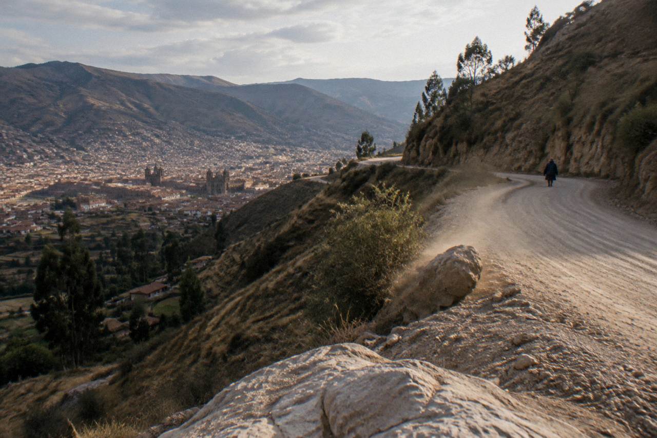 A winding mountain road climbing through dry Andean terrain toward a high pass