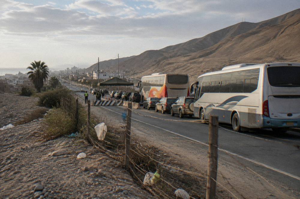 A highway checkpoint area with buses and cars waiting at roadside in the Peruvian altiplano