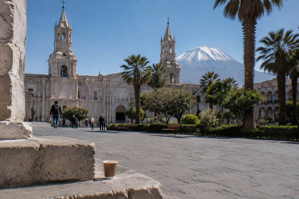 Arequipa's white volcanic stone cathedral under a clear sky with mountains behind