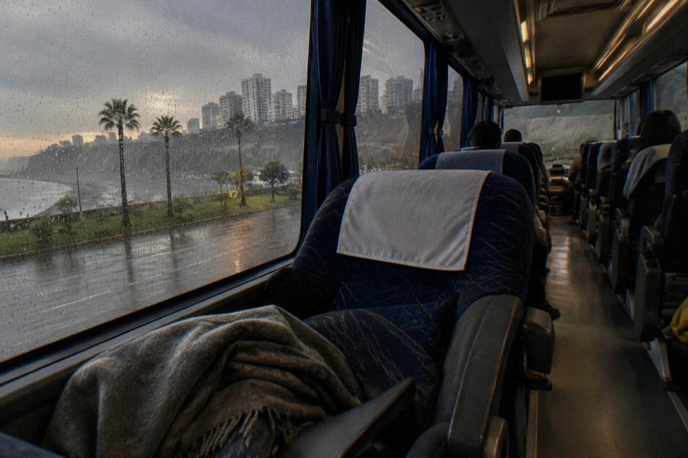 Interior of a long-distance tourist coach with wide reclining seats and large scenic windows