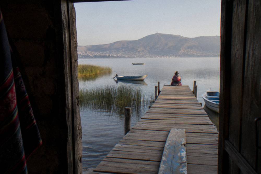 Wooden jetty on Lake Titicaca with small boats at Puno harbor