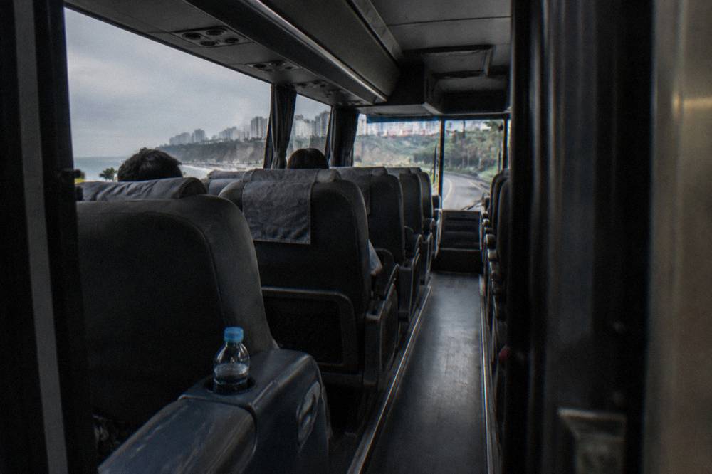 The interior of a modern long-distance coach with wide reclining seats in a 1-plus-1 layout