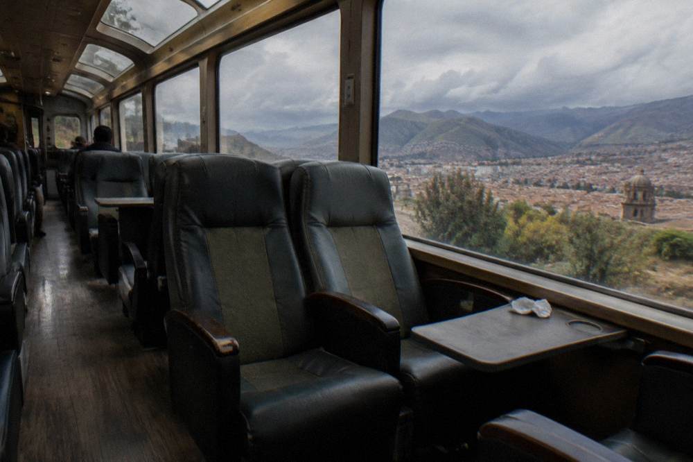 Interior of a panoramic train carriage with large windows and rows of seats
