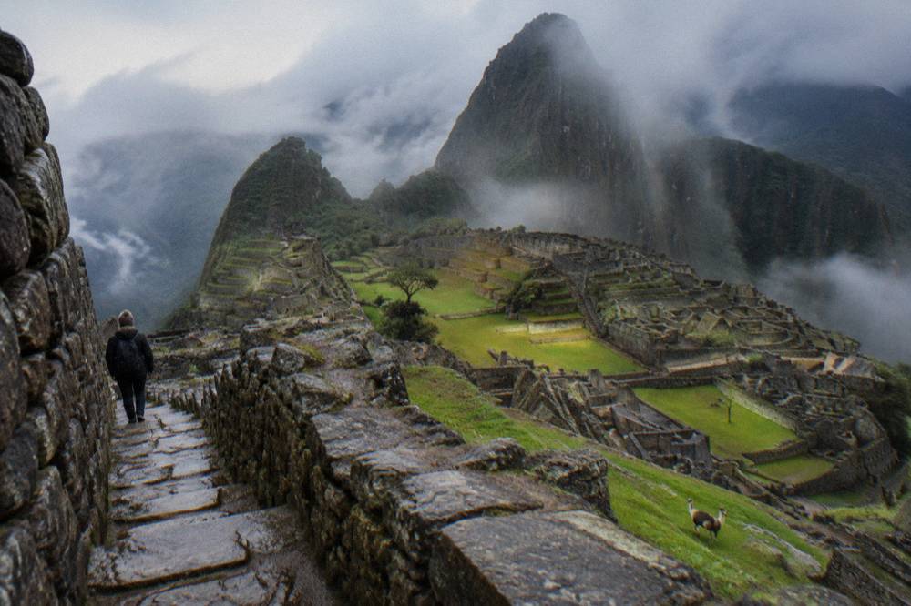 Ancient stone terraces and ruins on a green mountain ridge under morning light