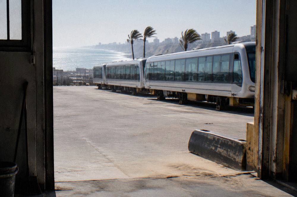 A tourist train with panoramic windows standing at a highland station platform