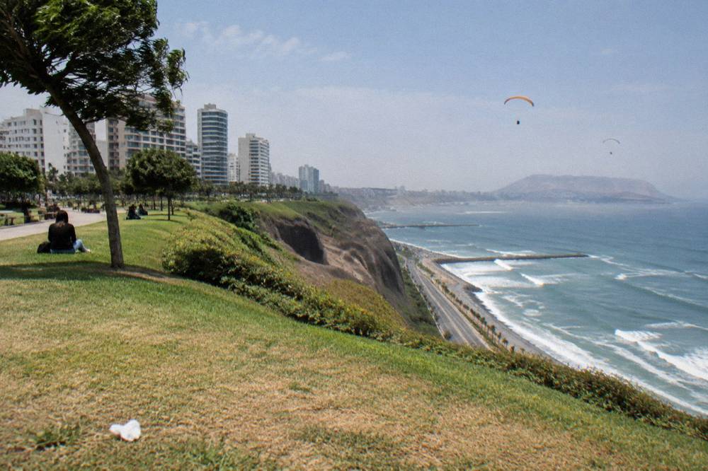 A seafront park in Miraflores with lawns and paragliders above the cliffs