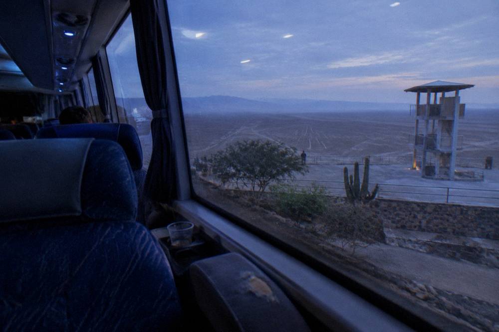 The interior of a modern long-distance bus with wide reclining seats and clean windows