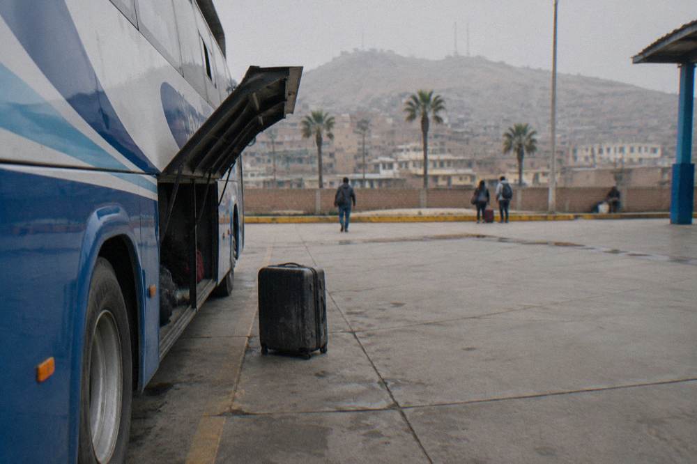 Busy bus terminal platform with a long distance coach loading luggage through the side hold