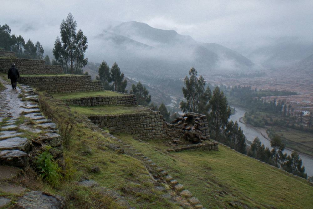Mountain ridge with ancient stone terraces above a river valley in morning mist