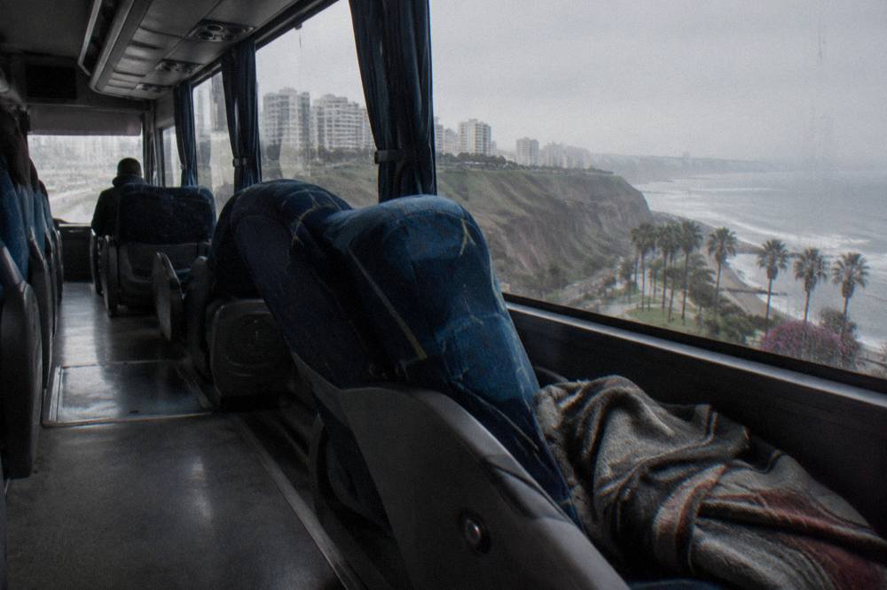 Interior of a long-distance touring bus with wide reclining seats and large windows