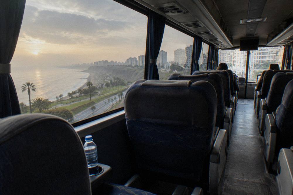 Interior of a long-distance coach with wide reclining seats and panoramic windows