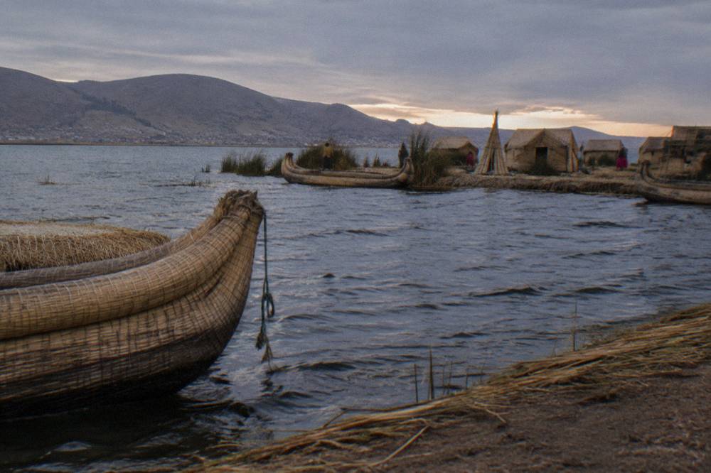 Reed boats and floating islands on Lake Titicaca under a wide blue sky