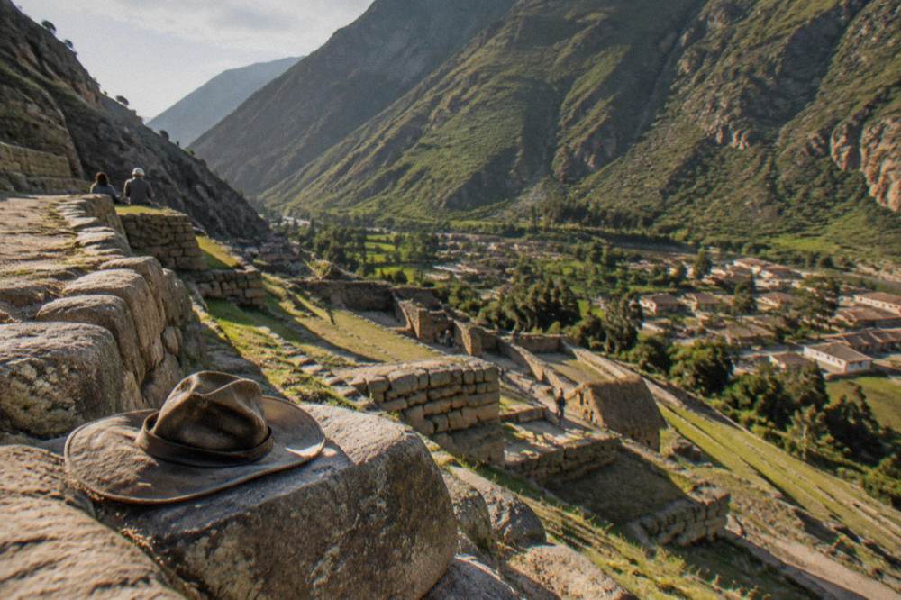 Terraced Inca stone walls of Ollantaytambo against green mountainside