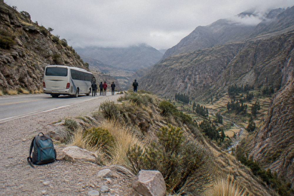 Tourist bus winding along a mountain road above a high Andean valley