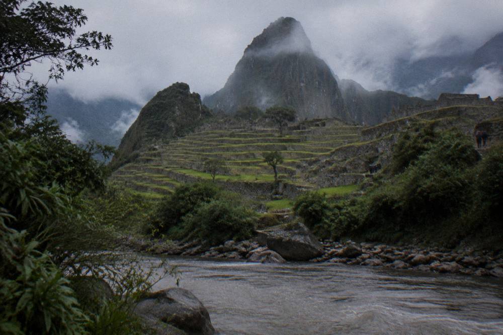 Stone terraces of Machu Picchu with the green saddle peak behind